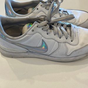 White Nike tennis shoes with metallic holographic swoosh